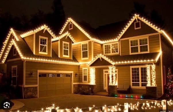 Warm white Christmas bulbs outlining the gables and eaves of a two story home